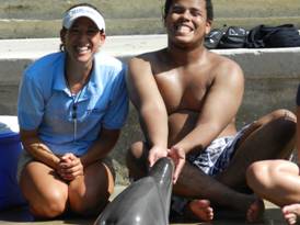 Transition Summer Camp student touches a dolphin.
