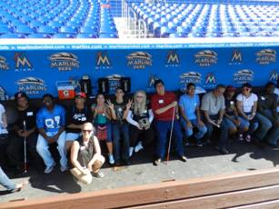 Summer camp students sit in the Miami Marlins dugout.