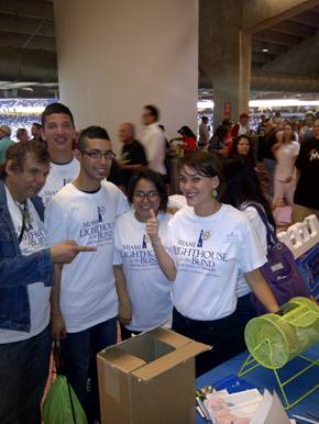 Emily Nostro draws the winning raffle ticket along with Miami Lighthouse Music students.