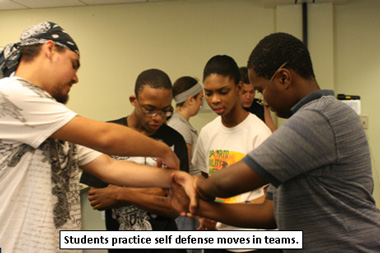 Students practice self defense moves in teams