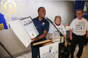 Jonathan Moses presents proclamation on behalf of Mayor Carlos Gimenez to Chairman of the Board Louis Nostro and CEO Virginia Jacko.